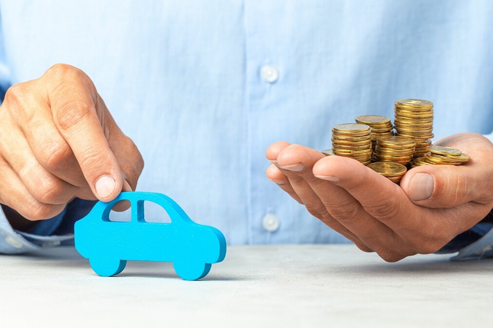 Voiture miniature en bois bleue et une pile de pièces de monnaie
