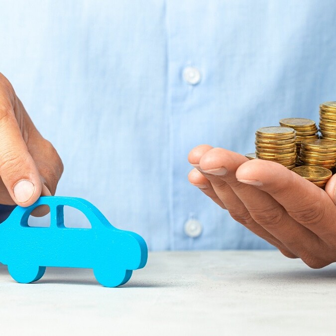 Voiture miniature en bois bleue et une pile de pièces de monnaie