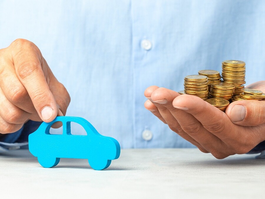 Voiture miniature en bois bleue et une pile de pièces de monnaie