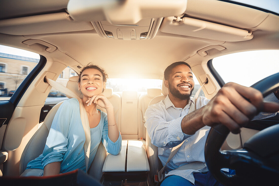 Couple métisse souriant en voiture
